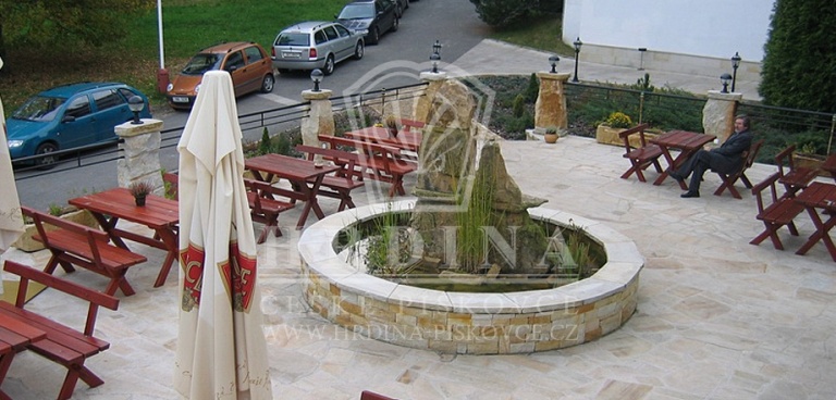 Fontána má kulatý kamenný límec jako posezení pro hosty