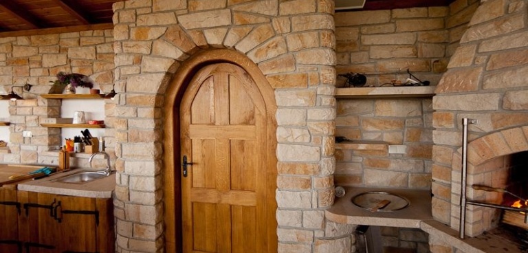 Dubové dveře vedoucí do vinného sklepa z kamene