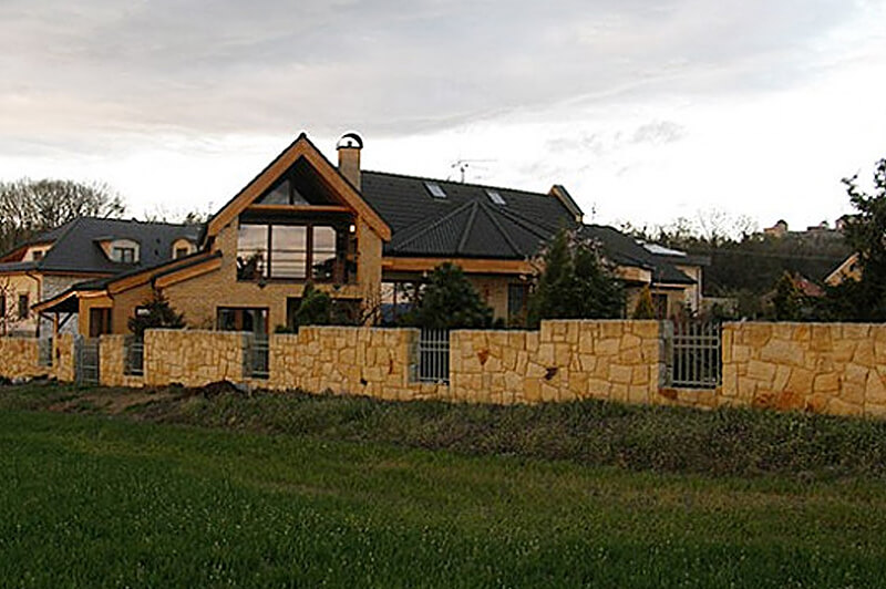 Plot z kamene a zahradní krb pod pergolou s kamenným komínem