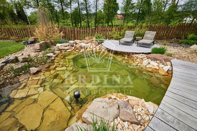 Zahradní jezírko z pískovce v zahradě s posezením