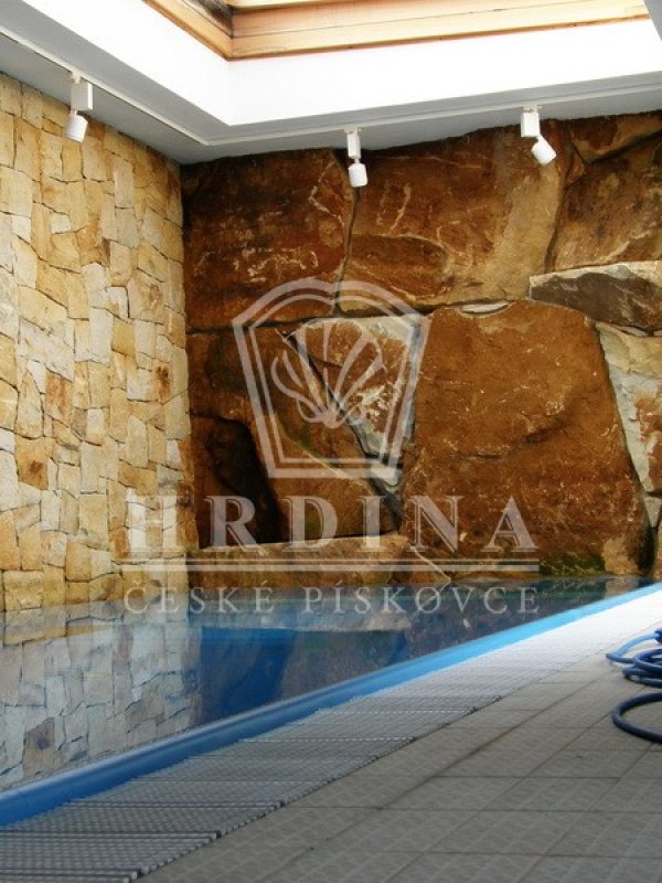 Kamenná zeď z pískovce kolem bazénu vytváří klidné prostředí