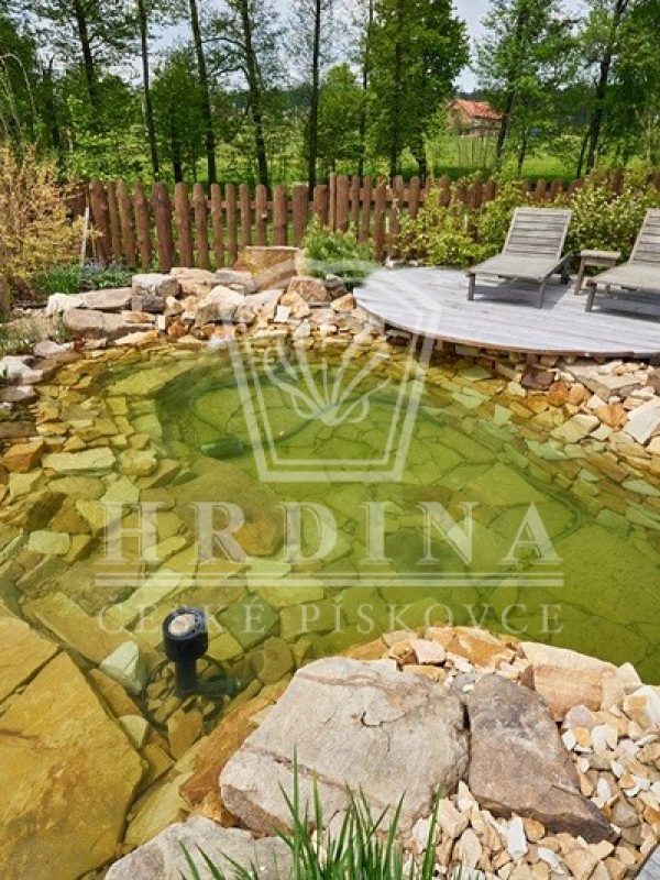 Zahradní jezírko z pískovce v zahradě s posezením